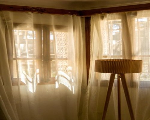 A bright living room in Mexico illuminated softly by natural sunlight coming through sheer curtains